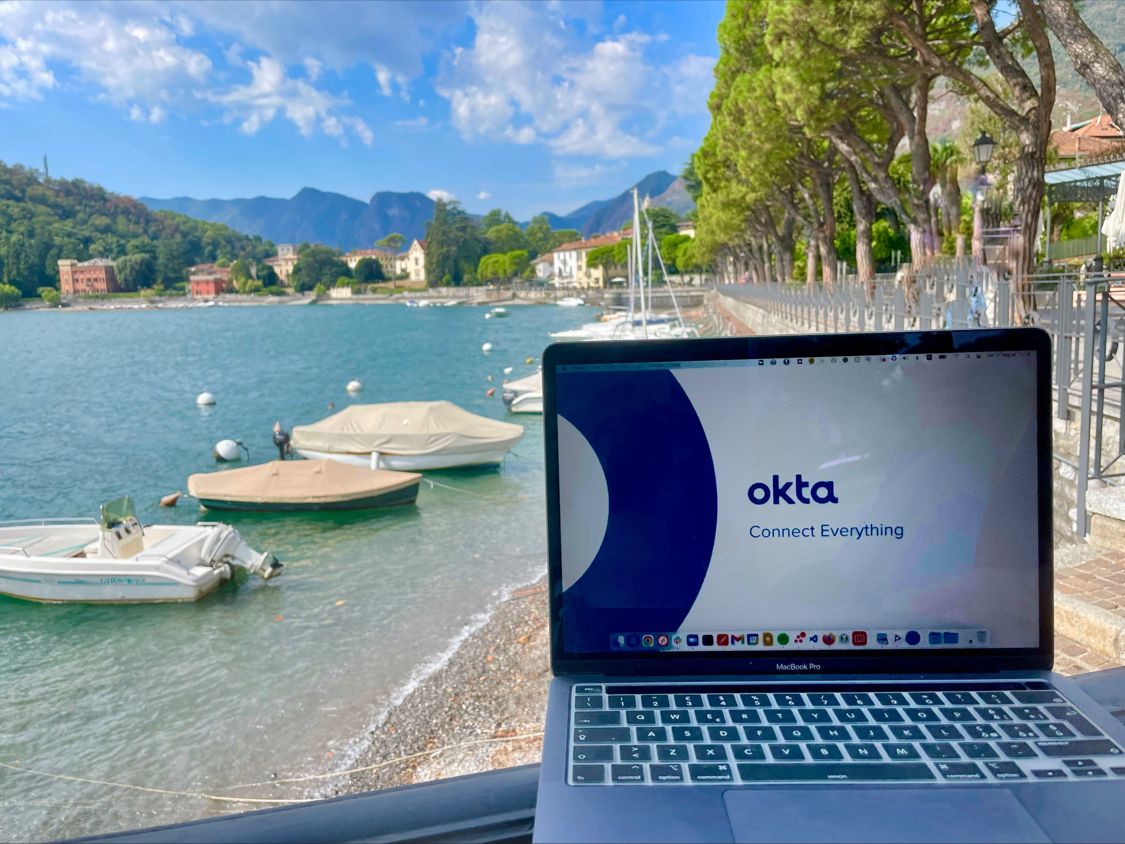 Laptop showing Okta in front of Lake Como